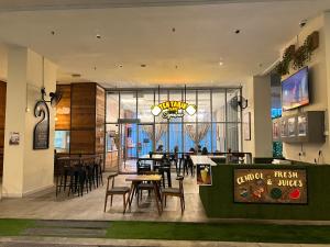 a restaurant with tables and chairs in a room at Empire Hostel Regalia in Kuala Lumpur