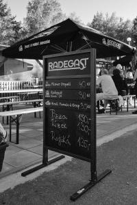 a chalkboard sign in a park with a tent at Obytný kontejner in Roudná