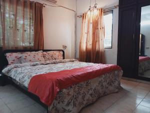a bedroom with a bed with a red blanket on it at happystay@casablanca2 in Chennai
