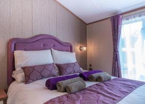 a bedroom with a purple bed with a purple headboard at Andrewshayes Orchard Retreat in Axminster