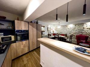 a kitchen with wooden cabinets and a stone wall at PESCULUM nel borgo in Pescocostanzo