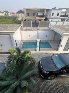 a black car parked in front of a building at Luxe Living:4Bed, TV, Pool& WiFi in Lekki