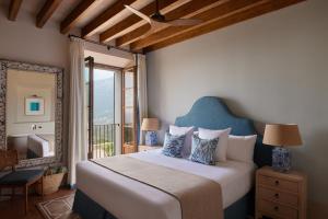 a bedroom with a large bed and a balcony at Son Bunyola in Banyalbufar