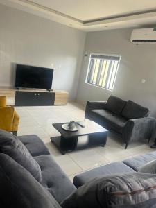 a living room with a couch and a table at Luxe Living:4Bed, TV, Pool& WiFi in Lekki