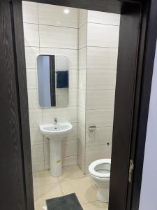a bathroom with a sink and a toilet at Luxe Living:4Bed, TV, Pool& WiFi in Lekki