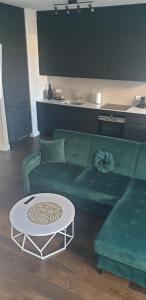 sala de estar con sofá verde y mesa en Apartament Mill Maria, en Wroclaw
