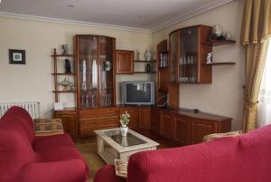 a living room with red chairs and a tv at Camino de las Mimosas: relax en un entorno idílico in Folgueras