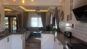 eine Küche mit weißen Schränken und ein Wohnzimmer in der Unterkunft Villa Vanilya in Dalyan
