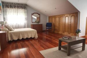 a bedroom with a bed and a table and a mirror at Camino de las Mimosas: relax en un entorno idílico in Folgueras