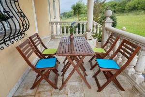 a wooden table and two chairs on a porch at Camino de las Mimosas: relax en un entorno idílico in Folgueras