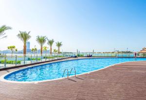 una piscina en un complejo con palmeras en New Arabian MINA By Azizi With Private Beach & Sea View 606, en Dubái