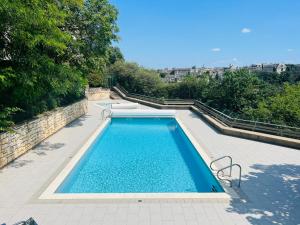 - une piscine d'eau bleue sur une terrasse dans l'établissement Le Rétro - Splendide appartement, à Poitiers