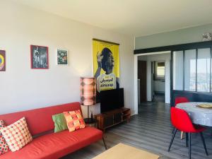 a living room with a red couch and a table at Le Rétro - Splendide appartement in Poitiers