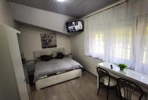 a bedroom with a bed and a desk with chairs at Art Room & Apartment in Ogulin