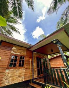 une maison en bois avec une véranda et une porte dans l'établissement Lay Back Villa Wooden House AC Hot shower High Speed Internet, à Krabi
