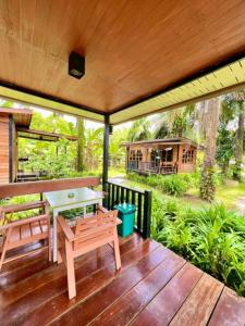 porche con mesa y bancos en una terraza de madera en Lay Back Villa Wooden House AC Hot shower High Speed Internet, en Krabi