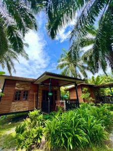 une maison en bois avec des palmiers devant elle dans l'établissement Lay Back Villa Wooden House AC Hot shower High Speed Internet, à Krabi