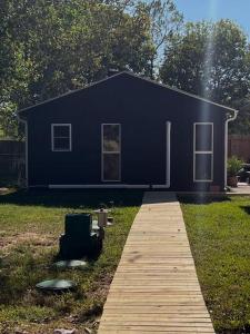 ein blaues Haus mit einem Holzsteg davor in der Unterkunft Quiet, Cozy Guesthouse with privacy in Manvel