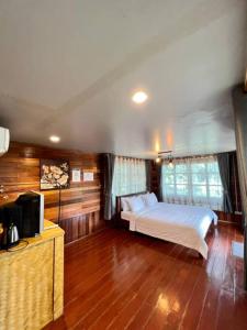a bedroom with a bed and a television in it at Lay Back Villa Wooden House AC Hot shower High Speed Internet in Krabi town