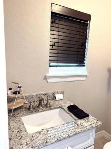 a bathroom with a sink and a window at Quiet, Cozy Guesthouse with privacy in Manvel
