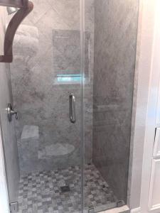 a shower with a glass door in a bathroom at Quiet, Cozy Guesthouse with privacy in Manvel +6 photos