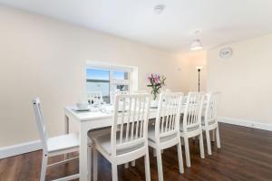 a white dining room with a white table and chairs at Property 444 - Clifden in Clifden