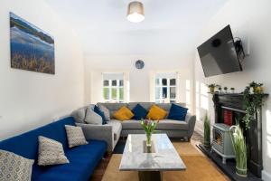 a living room with a blue couch and a fireplace at Property 444 - Clifden in Clifden
