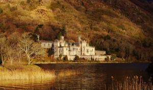 a large castle sitting on the shore of a lake at Property 444 - Clifden in Clifden