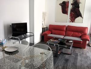 ein Wohnzimmer mit einem roten Sofa und einem Tisch in der Unterkunft Pizarro 32 - A las puertas del campo talaverano in Talavera de la Reina