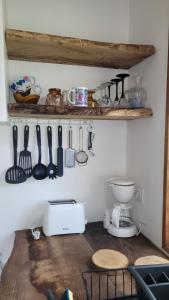a kitchen with a counter with utensils on a wall at Aux Nobles Acacias in Épagne-Épagnette