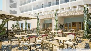 um restaurante ao ar livre com mesas, cadeiras e guarda-sóis em GranSerena Hotel em Torre Canne