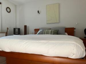 a bedroom with a large bed with white sheets at The Comfy Apartment in Ponte Capriasca