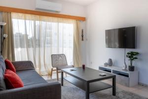 een woonkamer met een bank en een tafel bij Princess Residence in Ayios Dhometios