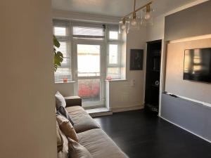 a living room with a couch and a tv at Quirky Hackney Wick 1 bed Flat! in London