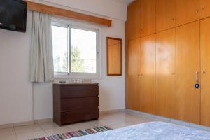 a bedroom with a dresser and a window at Princess Residence in Ayios Dhometios