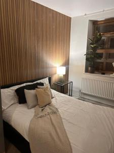 a bedroom with a white bed with a blanket on it at Quirky Hackney Wick 1 bed Flat! in London