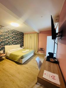 a bedroom with a bed and a desk and a television at Casa flowers 1 in Ciampino