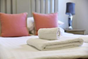 einen Stapel Handtücher auf dem Bett in der Unterkunft Shrewsbury 3 Bedroom Abbey Foregate in Shrewsbury