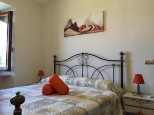 una camera da letto con un letto con cuscini arancioni sopra di La Cortevecchia a Lobbi