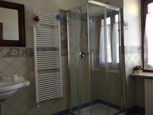 a bathroom with a glass shower and a sink at La Cortevecchia in Lobbi
