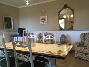 una sala da pranzo con tavolo, sedie e specchio di La Cortevecchia a Lobbi