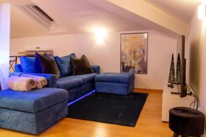 een woonkamer met een blauwe bank en een stoel bij LA MANSARDA Modern House in Verona