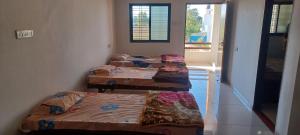 Ce dortoir comprend 3 lits superposés et une fenêtre. dans l'établissement Ashapura Home Stay, à Kevadia
