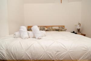 een wit bed met handdoeken erop bij LA MANSARDA Modern House in Verona
