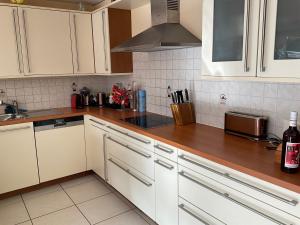 a kitchen with white cabinets and a counter top at Comfortable house with terrace close to Vevey and lake Geneva in Attalens