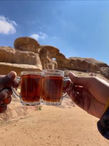 two people holding up glasses of tea at Moon Rum Camp in Wadi Rum