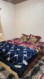 a bed with a blue comforter and pillows on it at Luminaire Homestay in Srinagar