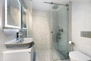a bathroom with a shower with a sink and a toilet at Casinha in Burgau +20 photos