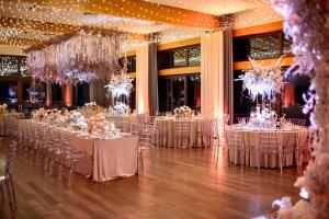 une salle remplie de tables avec des chaises blanches et des lustres dans l'établissement Kolumna Park Hotel, à Dobroń