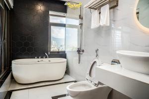 Baño blanco con aseo y lavamanos en Phu My Hai Hotel, en Da Nang